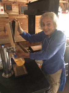 Carol B. HIllman serving cider in the barn next to the colonial orchard