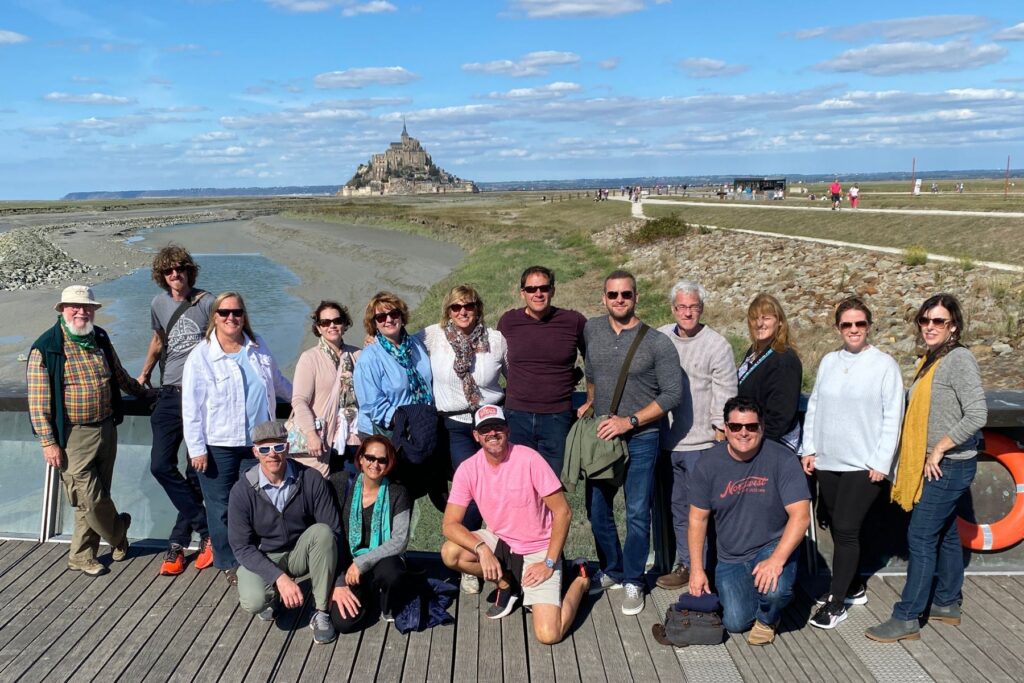 Guests on a Totally Cider Tour gather at Mont Saint-Michel in Normandy, France, during the 2022 France cider tour.
